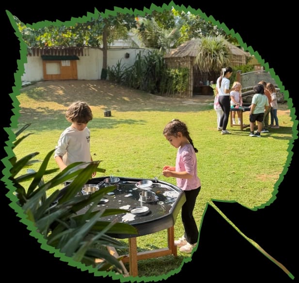 Group outdoor play at Forest Oasis Nursery Children playing outdoors under a tree at Forest Oasis Nursery